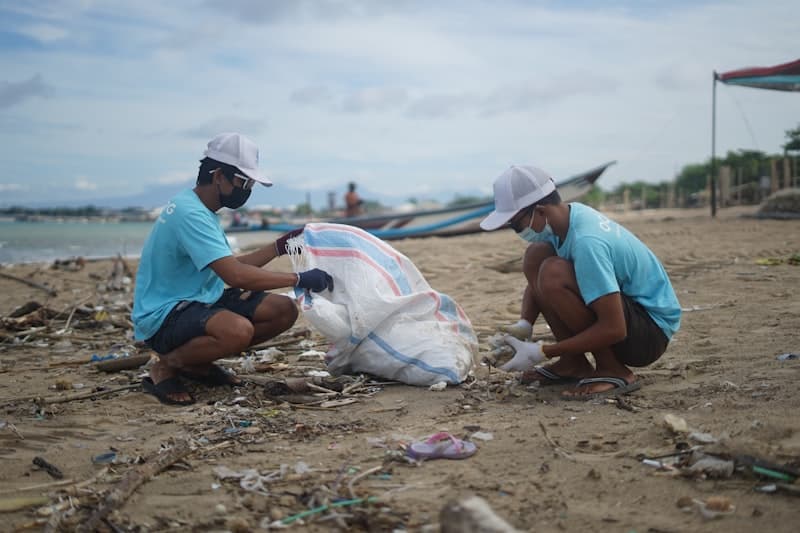 Volunteers picking up trash during a beach cleanup event