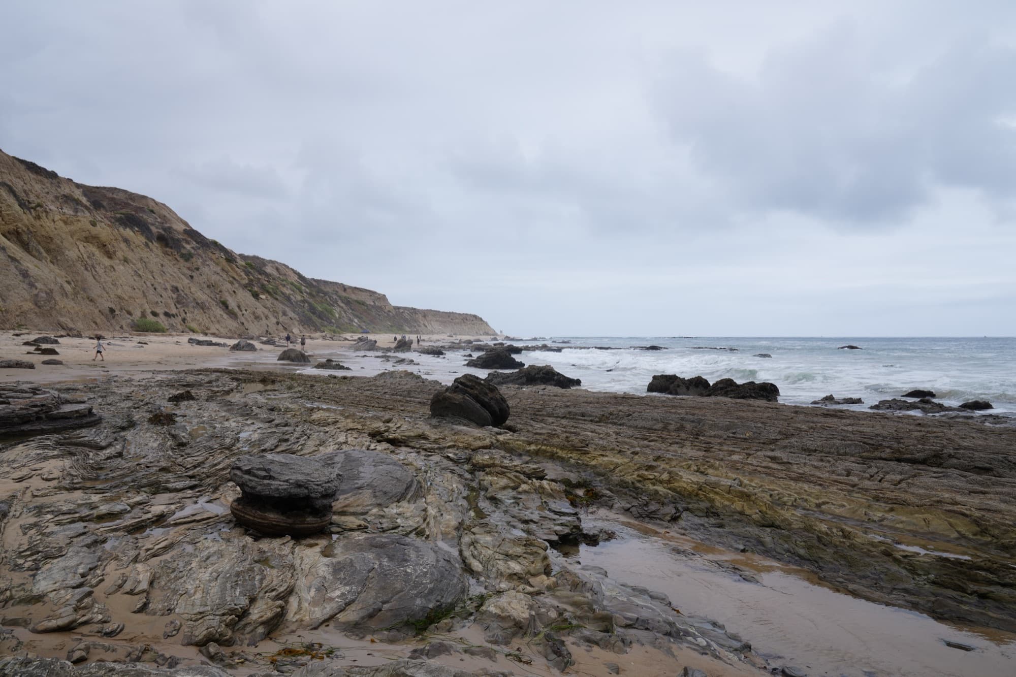 Rocky tide pools and a sandy beach beneath coastal bluffs at the Crystal Cove State Marine Conservation Area in Orange County
